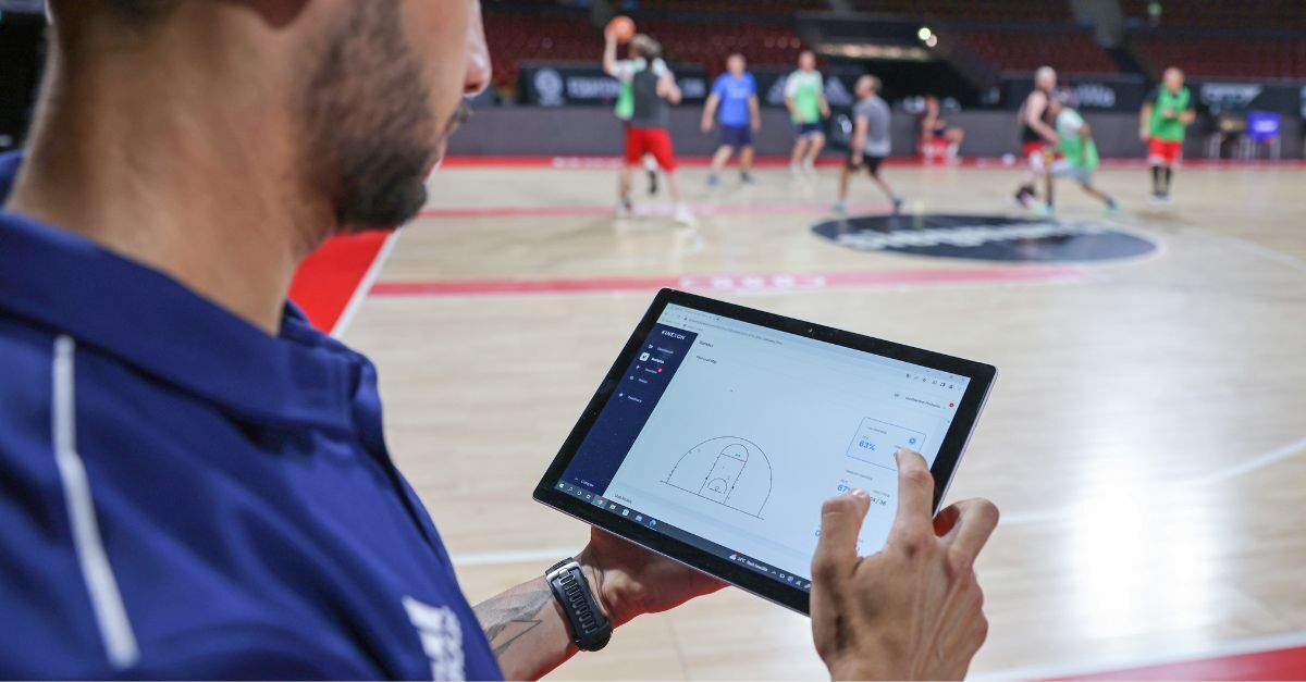 a coach uses a sports analysis software to see how his players are performing during practice.