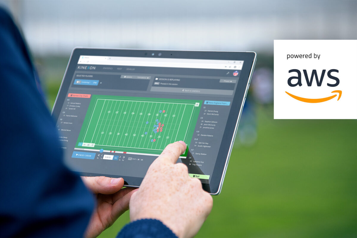 A coach is looking at the KINEXON Sports app that is displaying the live performance and load management data of a soccer team during a match.
