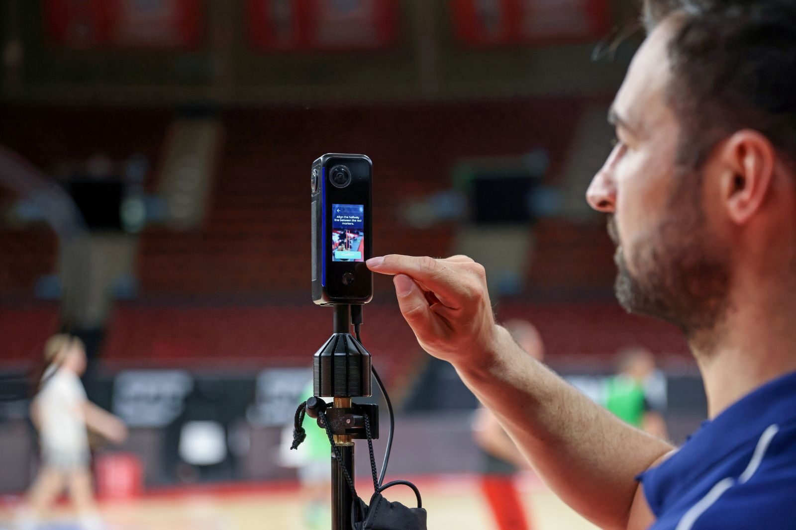 a coach sets up a camera for video that he will upload to a sports analysis software and get back data on his players.