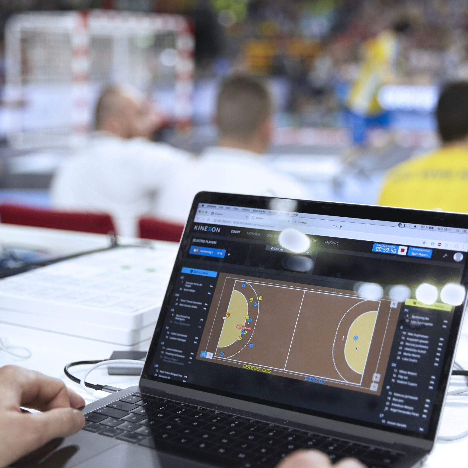 A sports analytics dashboard is reviewed by a sports scientist during a professional team handball game in Germany.