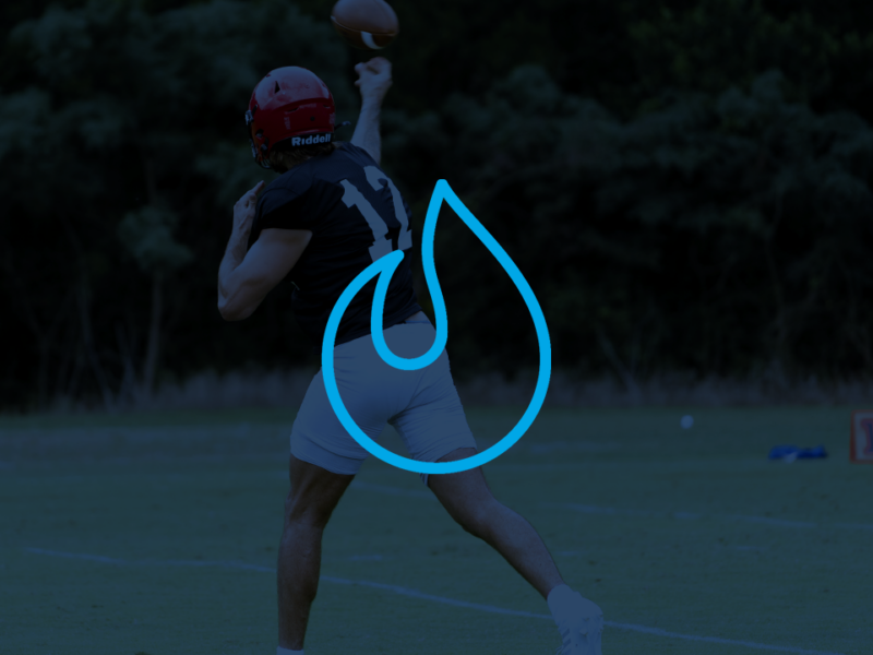 A quarterback makes a throw during a practice while wearing a gps wearable device.