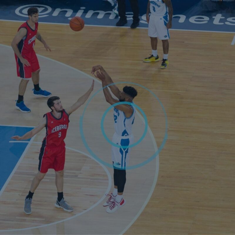 Basketball player taking a jump shot in a game as his mechanical loading is being monitored by a player tracking system.